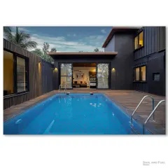 A container home with a private pool, viewed from the wooden deck. The sliding glass doors create a seamless transition between the modern interior and the inviting outdoor space, perfect for a relaxing getaway.
