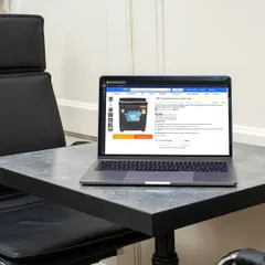A clear view of a washing machine listing on the laptop screen, proving our capability in handling large appliance photography.