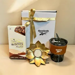 For this Diwali corporate gift, I curated a hamper for Reebok that balances elegance and utility. It features a branded tumbler, a decorative lotus diya, and premium almond brittle, all beautifully packaged in a custom gift box.