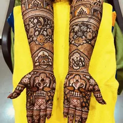A stunning floral and architectural design. This mehndi combines the softness of rose patterns with the grandeur of palace domes, along with peacock figures on the palms.