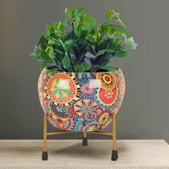 This metal apple-shaped pot features a vibrant Rajasthani Meena print and comes with a golden stand. It's a perfect fusion of traditional Indian art and modern design, ideal for adding an ethnic touch to your decor.