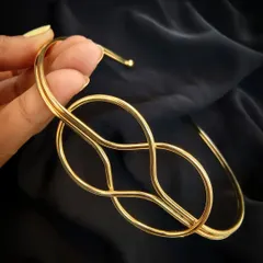 A close-up product shot of the Layla Lotus gold Hasli, highlighting its intricate and modern knot design.