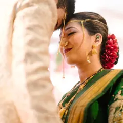 A beautiful, tender moment during a Maharashtrian wedding ritual. The bride's expression shows the mix of emotion and happiness that fills the day.