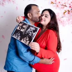 A happy couple shares their excitement by holding up their baby's ultrasound picture. This is a popular and personal way to announce your pregnancy during a maternity photoshoot.