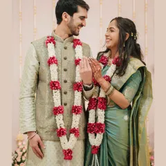 A sweet, interactive moment post-ceremony, where the couple's happy expressions and beautiful garlands tell a story of love and commitment.