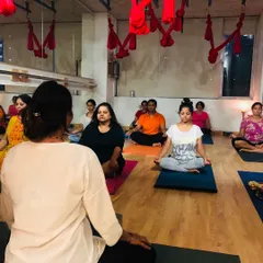 Here I am guiding a meditation session in the studio. I provide personal attention to help each student connect with their inner stillness and find balance during our group yoga classes.