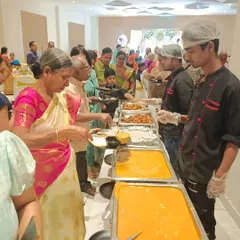 We believe in attentive service for all your guests. Here, one of our staff members assists a guest at a wedding anniversary celebration, ensuring everyone feels welcomed and cared for.