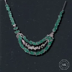 An emerald statement necklace that transforms every moment into a timeless fairytale. This three-tiered piece features raw emerald beads interspersed with diamond floral motifs, creating a look of organic luxury.