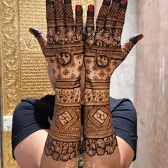 A bold and beautiful full-arm design for a family member. This henna features personalized initials in a geometric frame on the forearm, complemented by traditional elephant motifs and intricate fill-work.