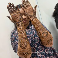 A full-coverage bridal mehendi that extends up the arm. This design is filled with a variety of traditional patterns, including checks, florals, and paisleys, for a truly grand look.