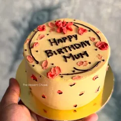 A lovely Lotus Biscoff mini cake, held in hand to show its cute, personal size. Perfect for celebrating your mum's birthday in a small, intimate way.
