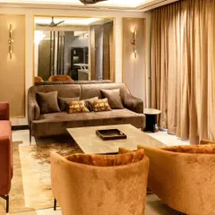 This living area demonstrates our skill in layering textures and colors. We combined sofas in different rich tones, a hide rug, and a large mirror with a gold frame to create a space that feels both glamorous and inviting.