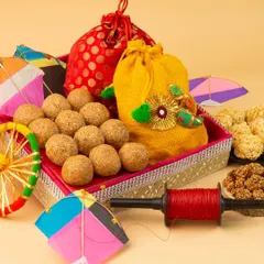 This composition was designed to showcase a festive gift hamper for Makar Sankranti. The arrangement highlights the variety of sweets and the decorative packaging, making it an ideal image for e-commerce sites or social media promotions.