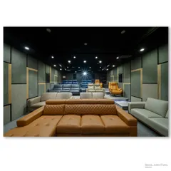 Another view of the home theater showroom, with the projector light creating a focal point. The acoustically treated walls and professional lighting demonstrate the technical quality of the installations.