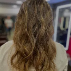 Soft, beachy waves with subtle highlights, expertly styled by one of our students. This shows their understanding of modern styling trends and techniques.
