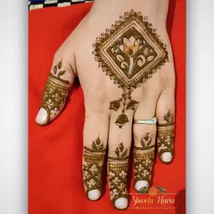 A simple and elegant henna design perfect for any occasion. This piece features a single diamond-shaped floral motif on the back of the hand with delicate patterns on the fingers.