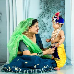 Celebrating Janmashtami with a special Krishna-themed photoshoot. Here, a mother shares a loving look with her son, who is beautifully dressed as little Krishna, complete with traditional attire and jewelry.