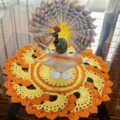 This vibrant orange and yellow crochet doily, shown here as a base for a decorative piece, adds a burst of color and handmade charm to any tabletop.