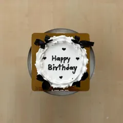 A top-down view of a vintage bento cake, showing the "Happy Birthday" message surrounded by little hearts.