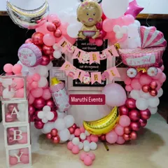 A full and festive 'Baby Girl' welcome ceremony decoration. The pink and white balloon ring is filled with details like a baby carriage, a milk bottle, and 'BABY' blocks.