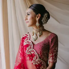 A classic bridal bun adorned with delicate white gajra. This hairstyle is timeless and elegant, perfect for pairing with a traditional red lehenga for the wedding ceremony.