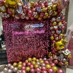 A full shot of the photo wall for the 'House of Santushti' event, showcasing the complete balloon frame. The mix of metallic and chrome balloons in pink, gold, and silver provides a rich texture that photographs beautifully and elevates the brand's image.
