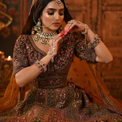 This pose highlights the detailed hand jewelry and henna, with the makeup providing a stunning focal point.