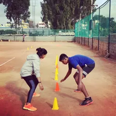 Advanced players participate in an agility and reaction drill using cones. My competitive program includes intensive fitness conditioning to improve on-court speed and stamina.
