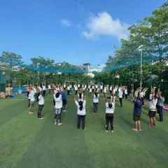 A large group session on an open turf. I am experienced in leading big groups, ensuring everyone feels included and guided throughout the practice.