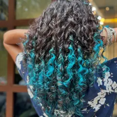 The vibrant blue against the dark natural hair creates a stunning contrast.