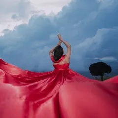 A dramatic solo portrait of the bride-to-be, with her vibrant red gown against a stormy sky. This shot showcases our artistic and creative approach to pre-wedding photography.