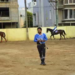 A photo of our coach during a training camp, with a rider in the background. Our trainers are always on the ground, providing real-time feedback and instruction.