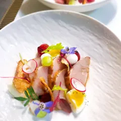 Delicate slices of Kanpachi (Amberjack) served with yuzu, miso, a perfectly cooked quail egg, and crispy taro root. A study in Japanese-inspired flavors.
