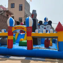 A large "Fun City" bouncy with a Mickey Mouse theme. This model includes a climbing wall, slides, and a spacious jumping area, perfect for large events.