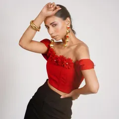 I styled this red off-shoulder top with 3D floral details and paired it with simple black trousers. The dramatic gold earrings complete this bold and romantic look.