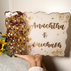 A hand holding the garland preservation nameplate to show its size. It's a beautiful way to welcome guests to your home.