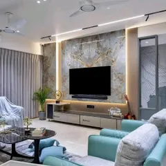 A complete living room design featuring a large TV unit with a marble-finish back panel and side-lit partitions. The color-coordinated furniture completes the elegant look.