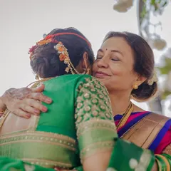 A heartfelt hug between the bride and her mother. This angle showcases the beautiful floral arrangement on her traditional bridal bun.