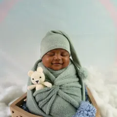 A precious moment captured as this newborn smiles while snuggled in a mint green wrap. I aim to catch these fleeting expressions that you will cherish forever.