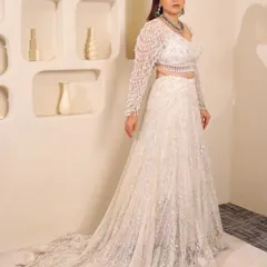 For the modern bride who dreams in white. This elegant pearl and sequin lehenga with a dramatic trail is perfect for a reception or engagement, proving that bridal glam comes in every color.