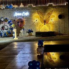 The poolside area decorated for a first birthday party at night. The reflection of the lights and balloons on the water adds an extra layer of magic to the celebration.