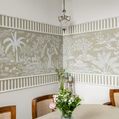 A corner view of the hand-painted Rajasthani mural in the 'Sushobit' dining room. The soft hues and striped border create a perfect harmony of heritage and contemporary charm.