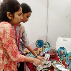 Customers browsing the items at my pop up stall. It is always rewarding to see people connect with my work, taking the time to examine the details of each handmade piece.