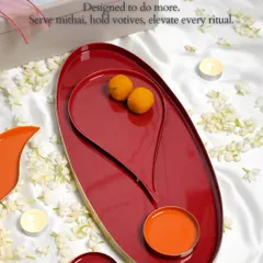 Designed to do more. This image shows the versatility of our Symbols of Celebration collection, featuring the large red oval tray with the Bindu plate nestled inside. It can be used to serve mithai, hold votives, or simply elevate every ritual.