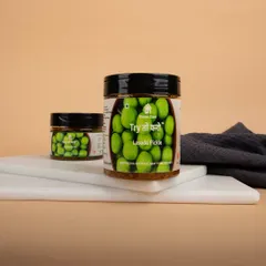 A styled shot of Lasoda Pickle jars on a marble board, showcasing the product in a simple, elegant setting.