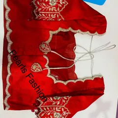 A bright red blouse with silver Zari work. The scalloped edges on the sleeves and back give it a modern look, and the tie-ups have heart-shaped details.