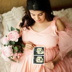 A beautiful solo portrait of the mother-to-be holding her sonogram picture, a quiet and personal way to celebrate her baby.