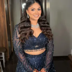 This bride's smile lights up the room. Her hair is styled in elegant, flowing waves, a timeless choice for any special occasion.
