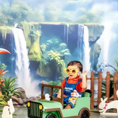 Because every jungle has its own little rockstar. This safari-themed shoot features a cool jeep, a stunning waterfall backdrop, and a happy little explorer ready for an adventure.