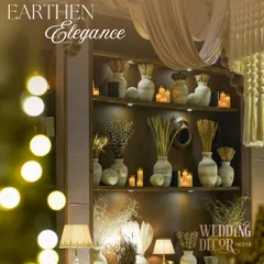 A beautifully styled shelf with rustic vases, dried botanicals, and warm candles. This 'Earthen Elegance' theme, with its focus on texture and soft lighting, is perfect for creating a refined and intimate atmosphere for any celebration.